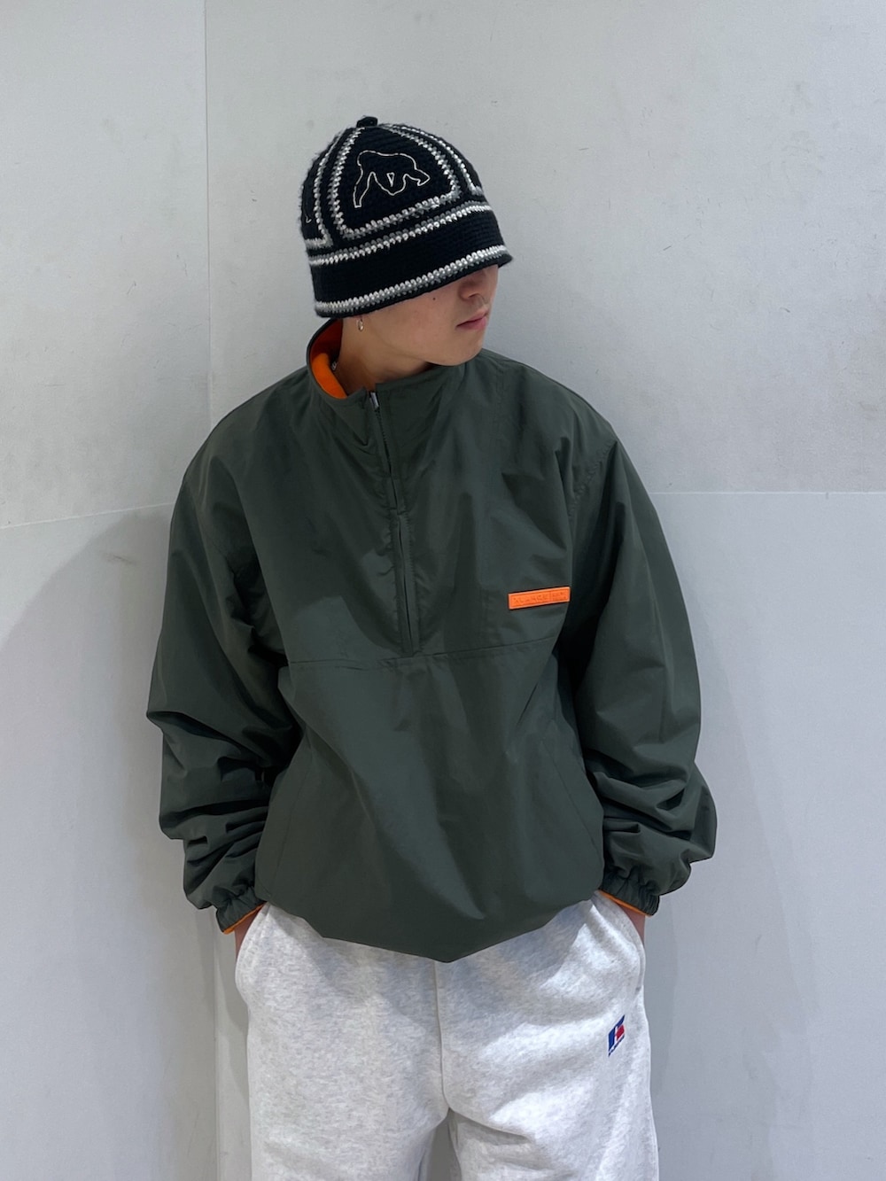 グリーン系のブルゾン、グレー系のスウェットパンツ、ブラック系のハットを着用したメンズの冬コーディネートの5枚目の写真