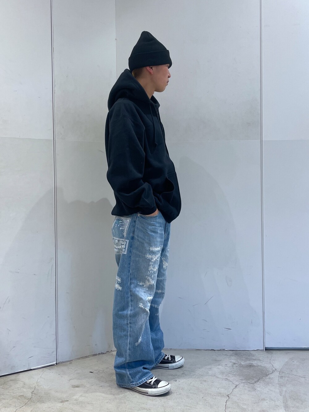 ブラック系のパーカー、ブルー系のデニムパンツ、ブラック系のニットキャップ/ビーニーを着用したメンズの秋コーディネートの3枚目の写真