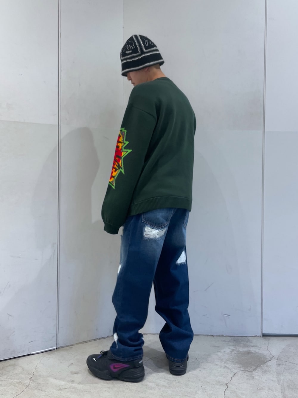 ブルー系のデニムパンツ、グリーン系のニット/セーターを着用したメンズの冬コーディネートの5枚目の写真