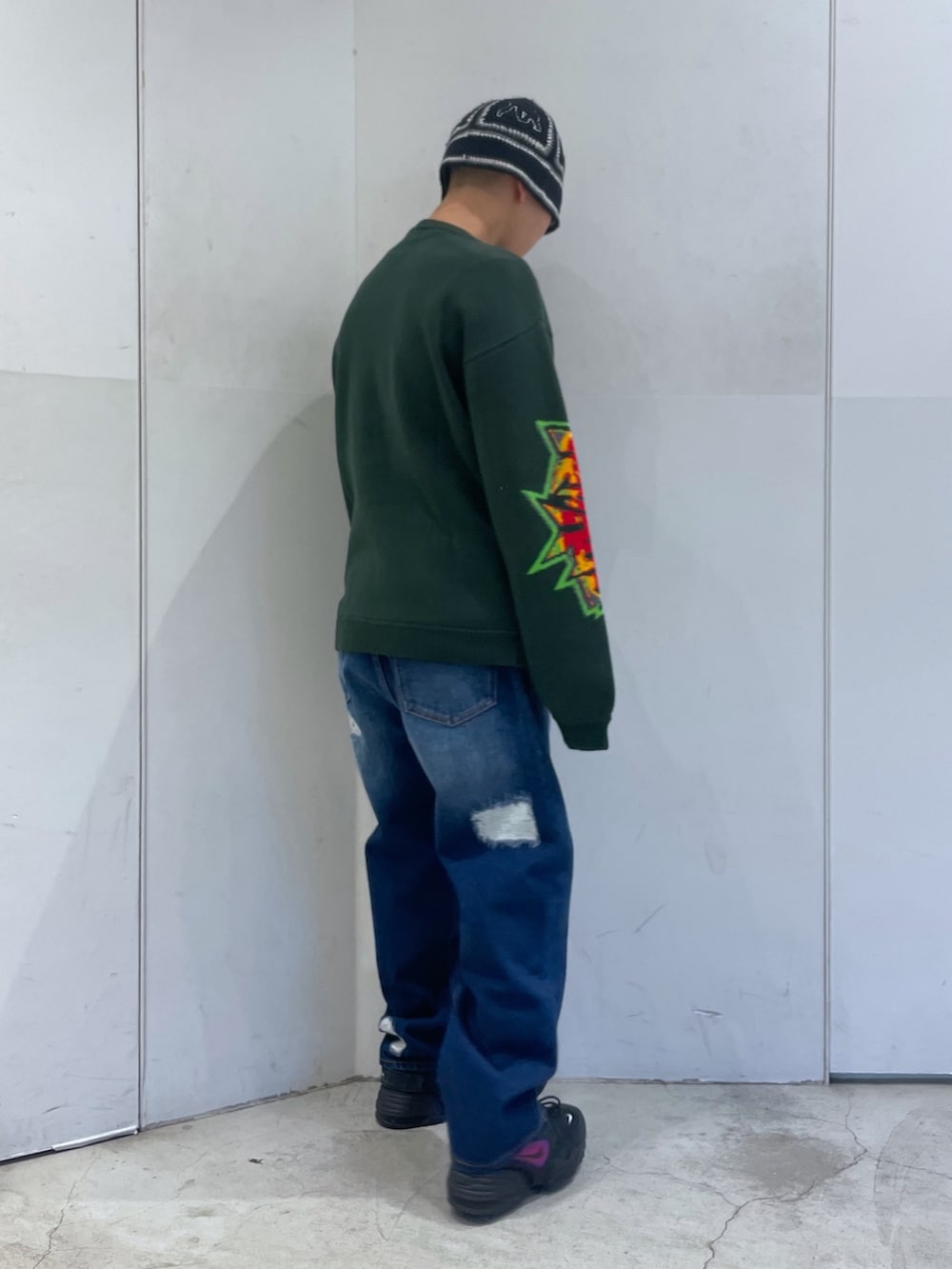 ブルー系のデニムパンツ、グリーン系のニット/セーターを着用したメンズの冬コーディネートの3枚目の写真