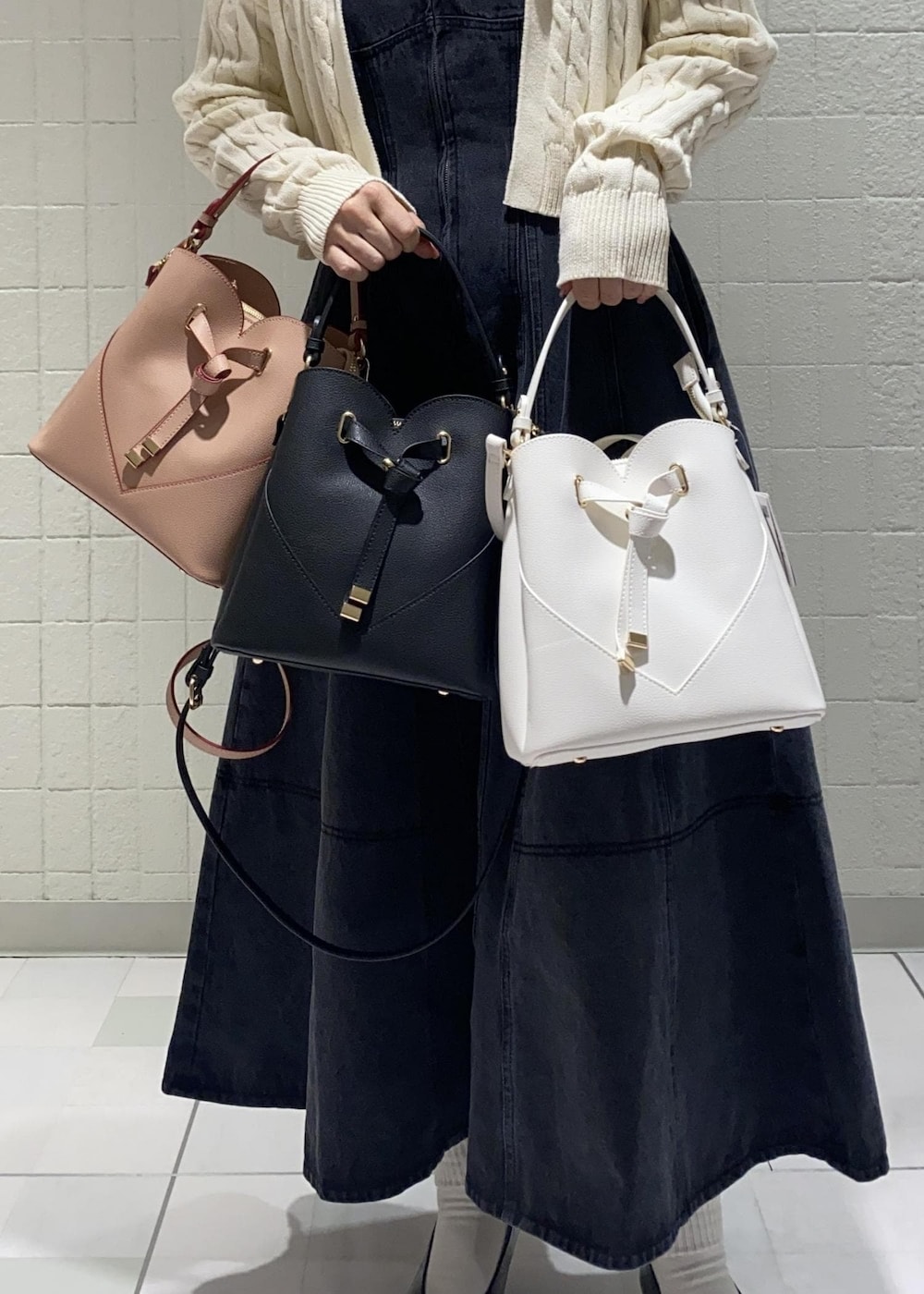 ブラック系のワンピース、ブラック系のパンプス、ホワイト系のカーディガン/ボレロを着用したレディースの冬コーディネートの2枚目の写真