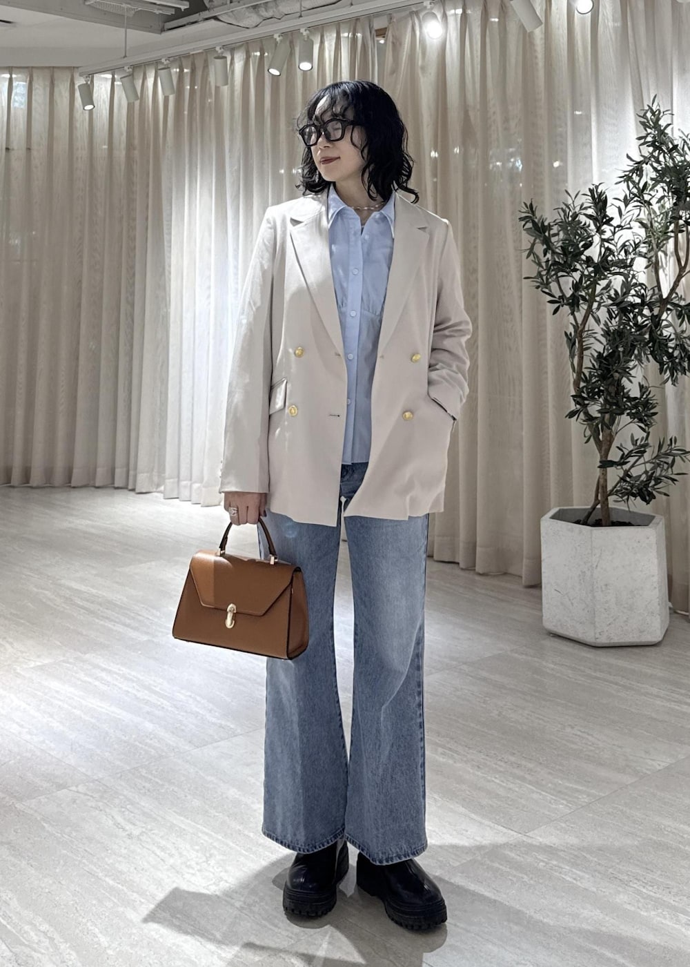 ブラック系のブーツ、イエロー系のハンドバッグ、ブルー系のシャツ/ブラウスを着用したレディースの冬コーディネートの2枚目の写真