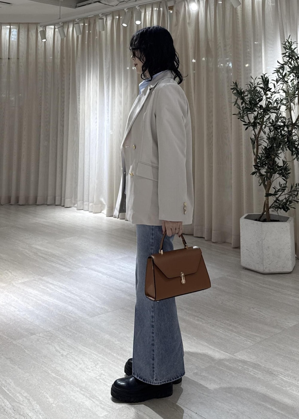 ブラック系のブーツ、イエロー系のハンドバッグ、ブルー系のシャツ/ブラウスを着用したレディースの冬コーディネートの4枚目の写真