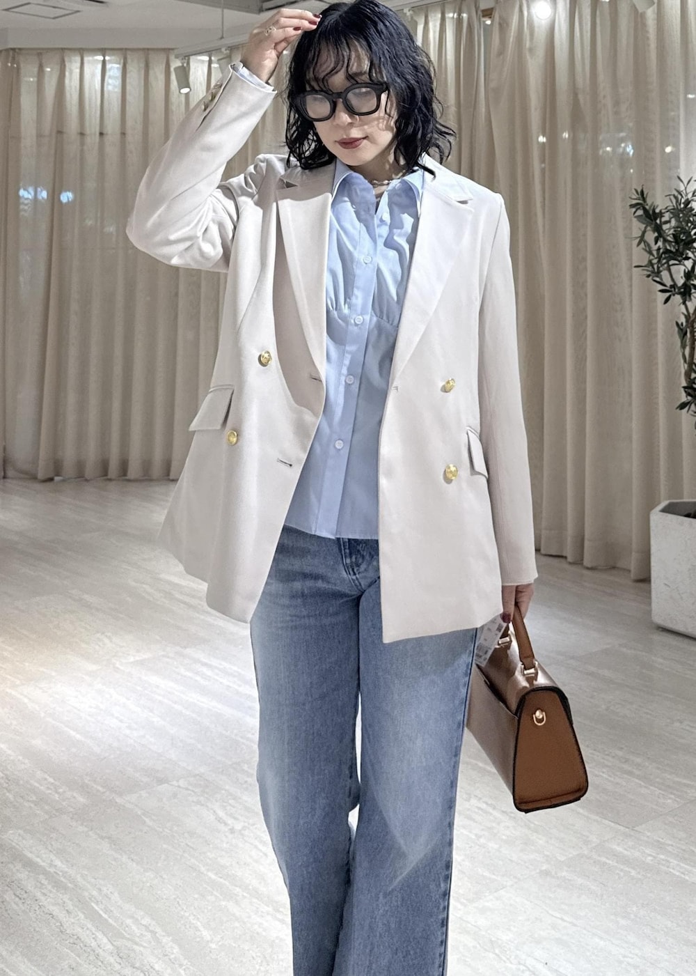 ブラック系のブーツ、イエロー系のハンドバッグ、ブルー系のシャツ/ブラウスを着用したレディースの冬コーディネートの6枚目の写真