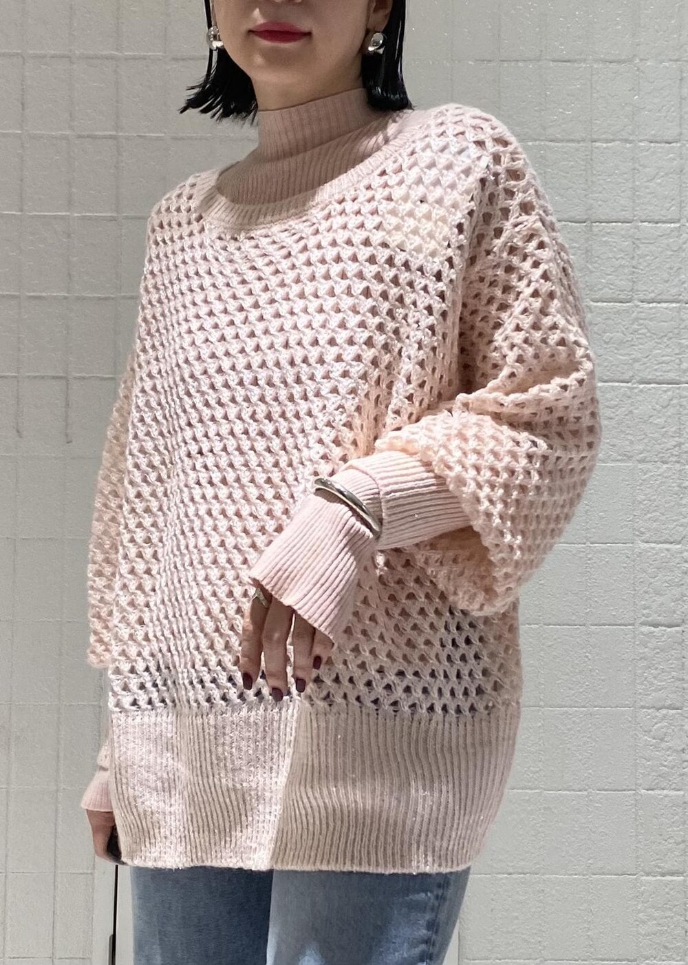 ピンク系のニット/セーター、ピンク系のニット/セーター、ブルー系のデニムパンツを着用したレディースの秋コーディネートの6枚目の写真