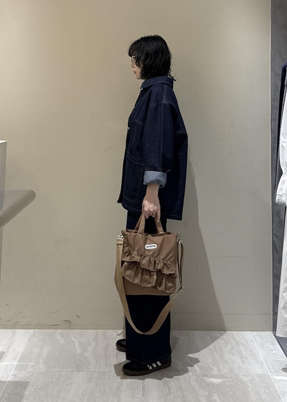 ブルー系のデニムパンツ、ベージュ系のトートバッグを着用したレディースの冬コーディネートの3枚目の写真