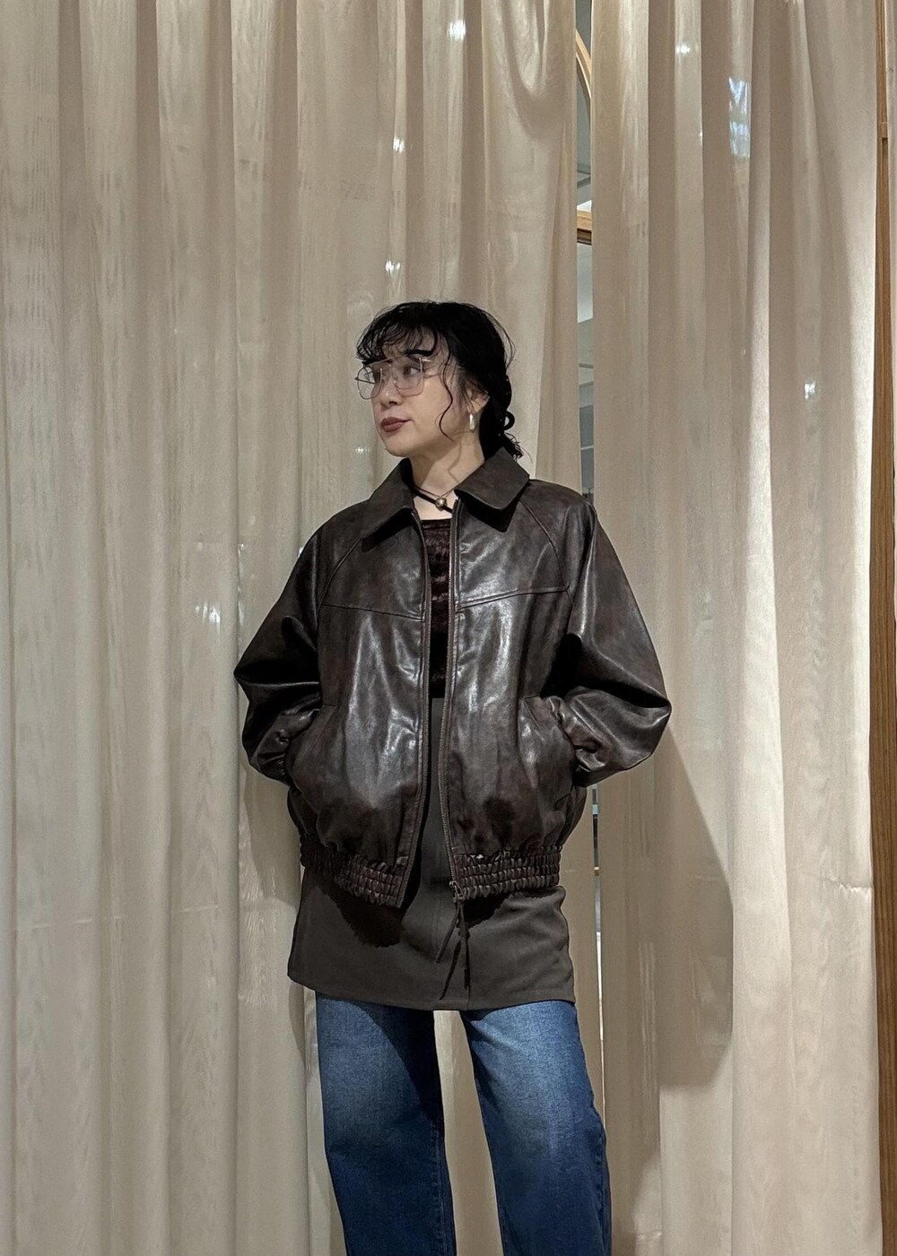 ブラック系のキャミソール、ブラック系のブーツ、ブラウン系のスカートを着用したレディースの秋コーディネートの6枚目の写真