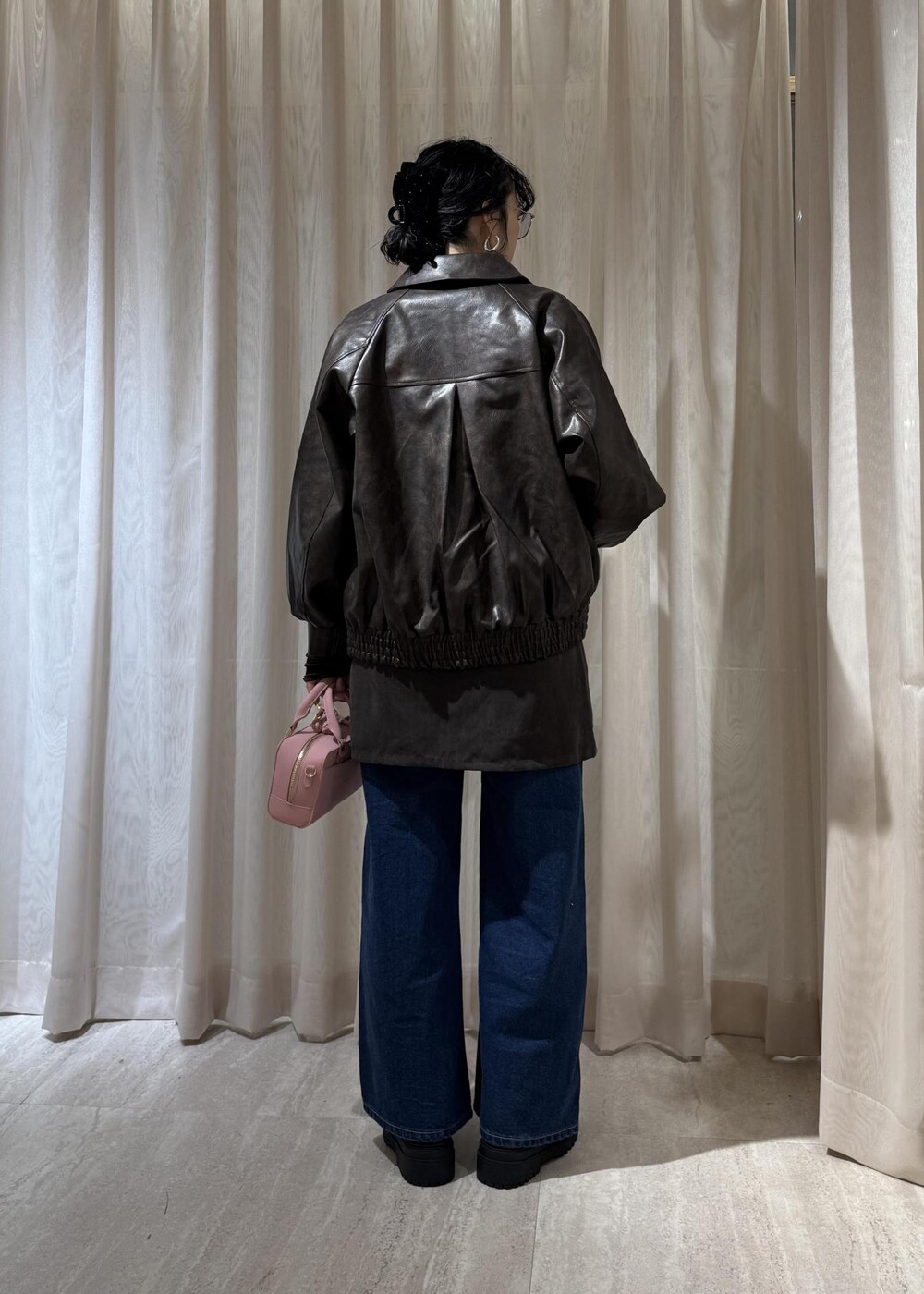 ブラック系のキャミソール、ブラック系のブーツ、ブラウン系のスカートを着用したレディースの秋コーディネートの4枚目の写真