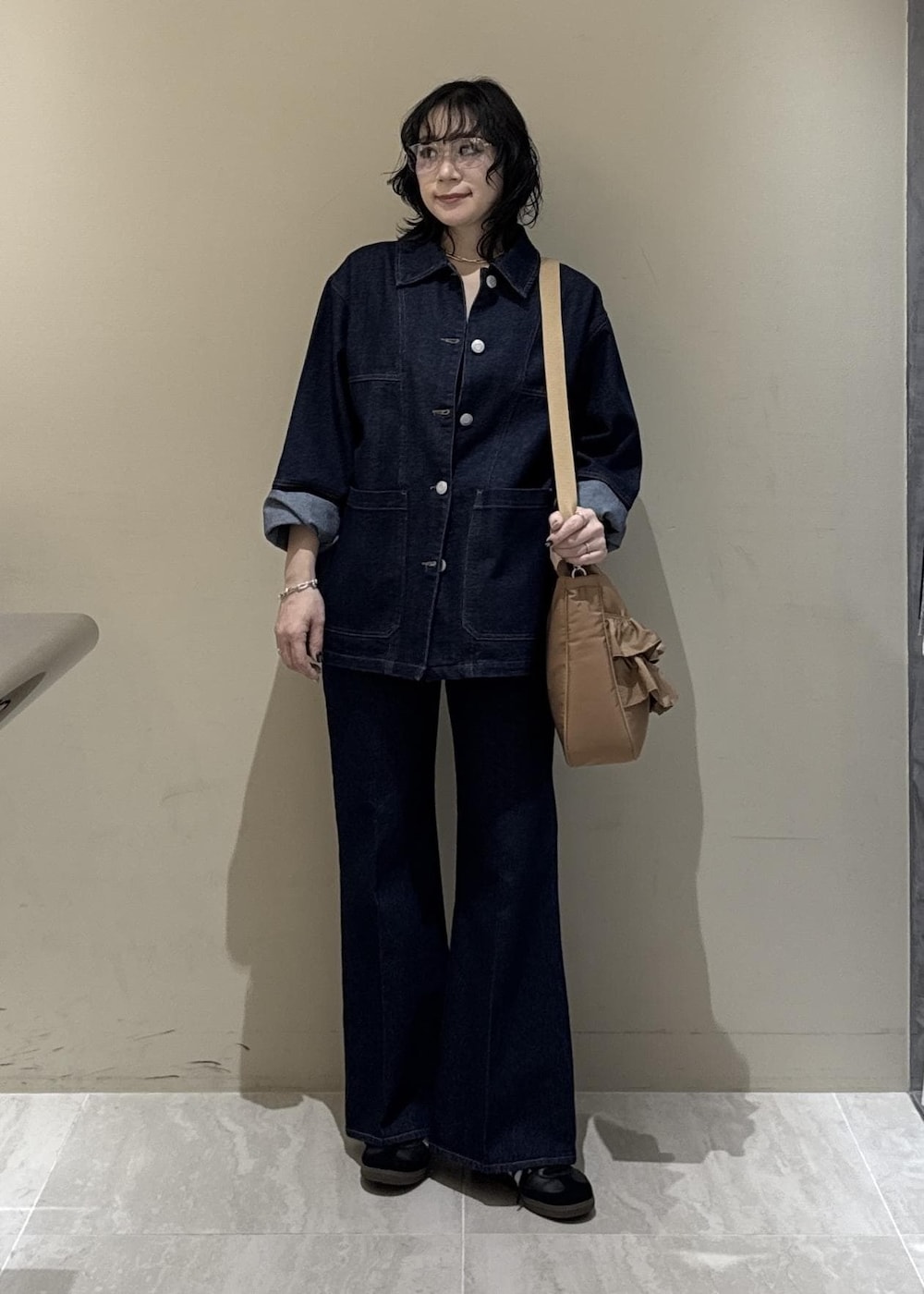 ブルー系のデニムパンツ、ベージュ系のトートバッグを着用したレディースの冬コーディネートの5枚目の写真