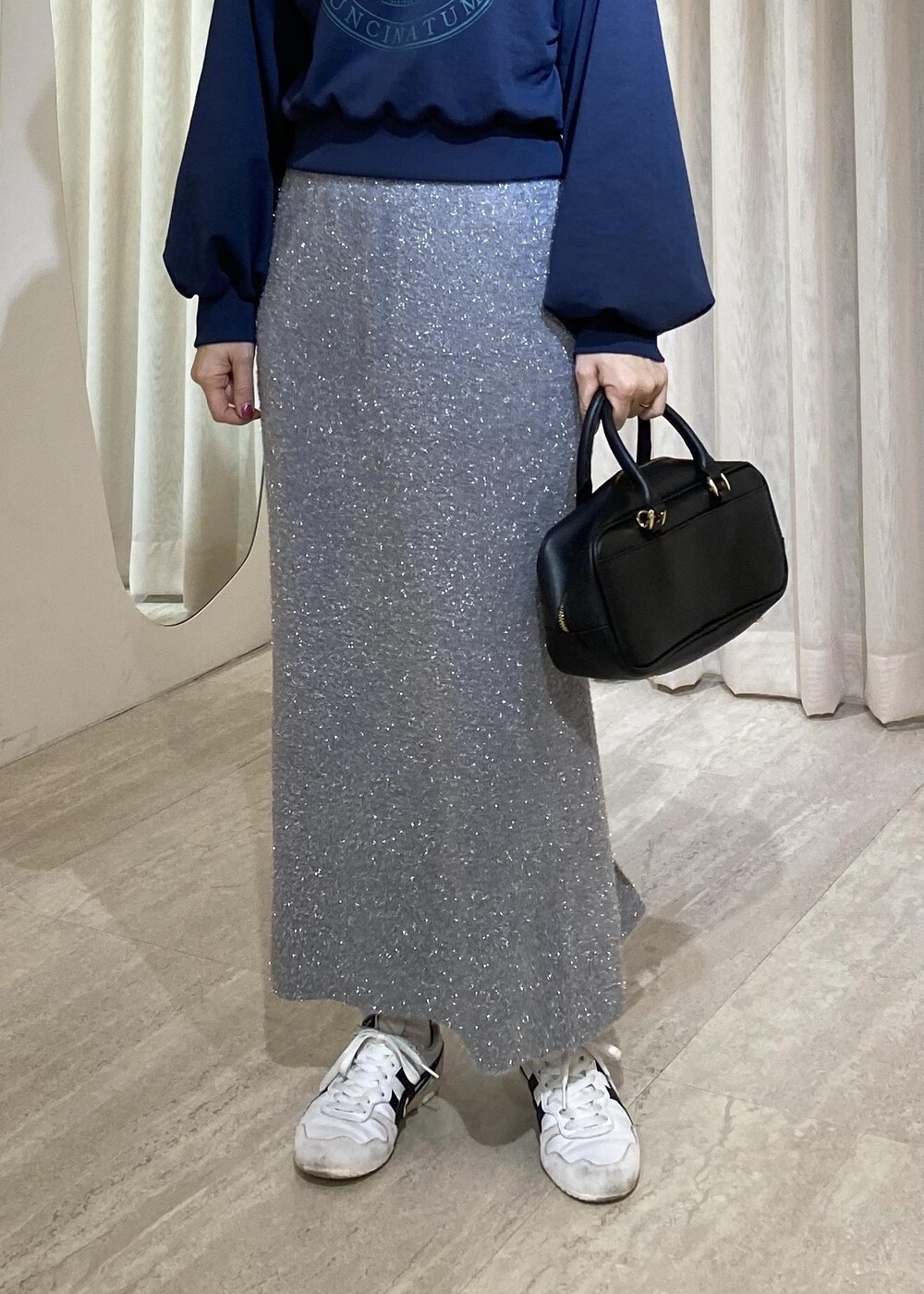 グレー系のスカート、ブルー系のスウェットを着用したレディースの冬コーディネートの3枚目の写真