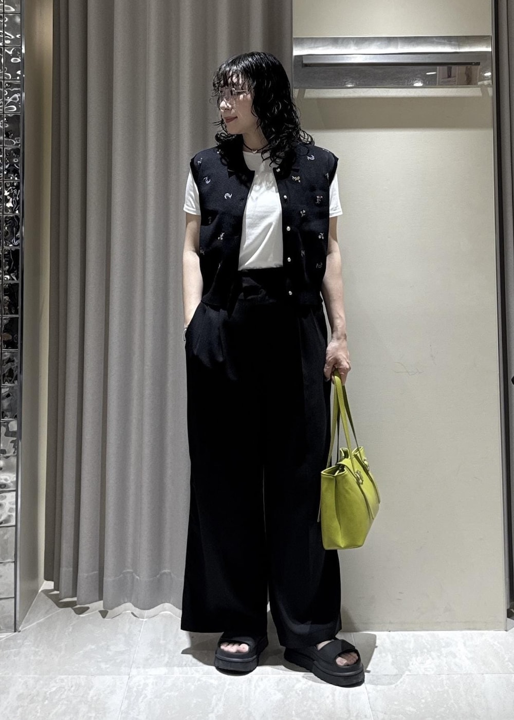グリーン系のトートバッグ、ブラック系のその他パンツ、ホワイト系のTシャツ/カットソーを着用したレディースの春コーディネートの2枚目の写真