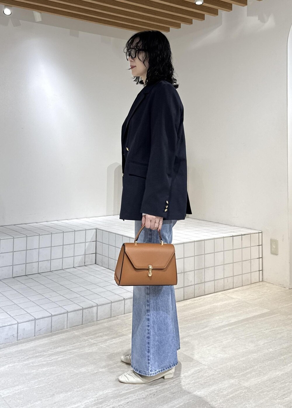 ホワイト系のパンプス、イエロー系のハンドバッグ、ホワイト系のTシャツ/カットソーを着用したレディースの冬コーディネートの6枚目の写真