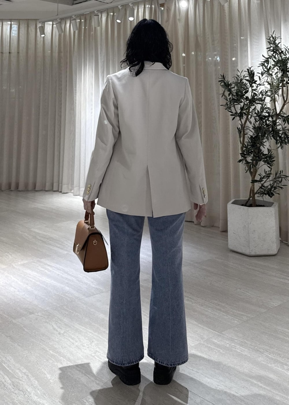 ブラック系のブーツ、イエロー系のハンドバッグ、ブルー系のシャツ/ブラウスを着用したレディースの冬コーディネートの5枚目の写真