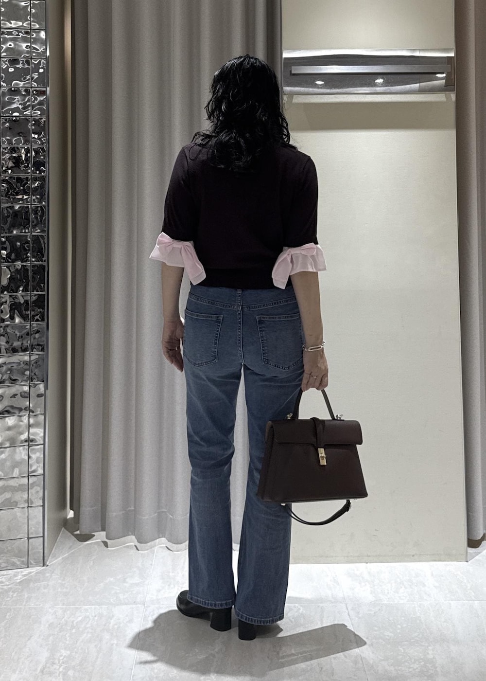 ブラック系のローファー、ブラウン系のカーディガン/ボレロ、ブルー系のデニムパンツを着用したレディースの秋コーディネートの6枚目の写真