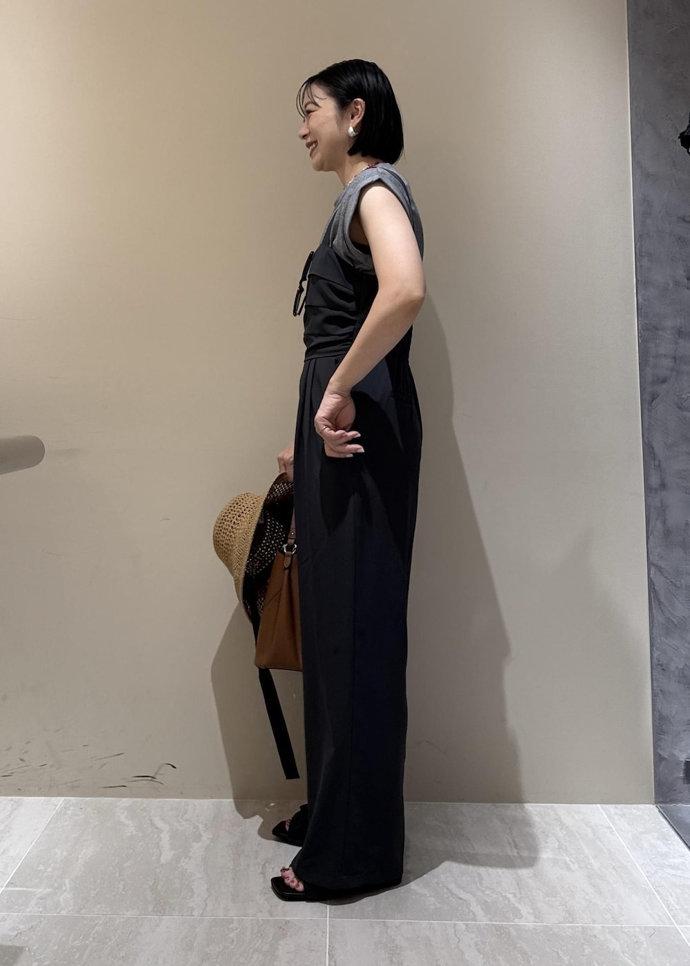 ブラウン系のショルダーバッグ、ブラック系のサンダル、グレー系のTシャツ/カットソーを着用したレディースの夏コーディネートの3枚目の写真