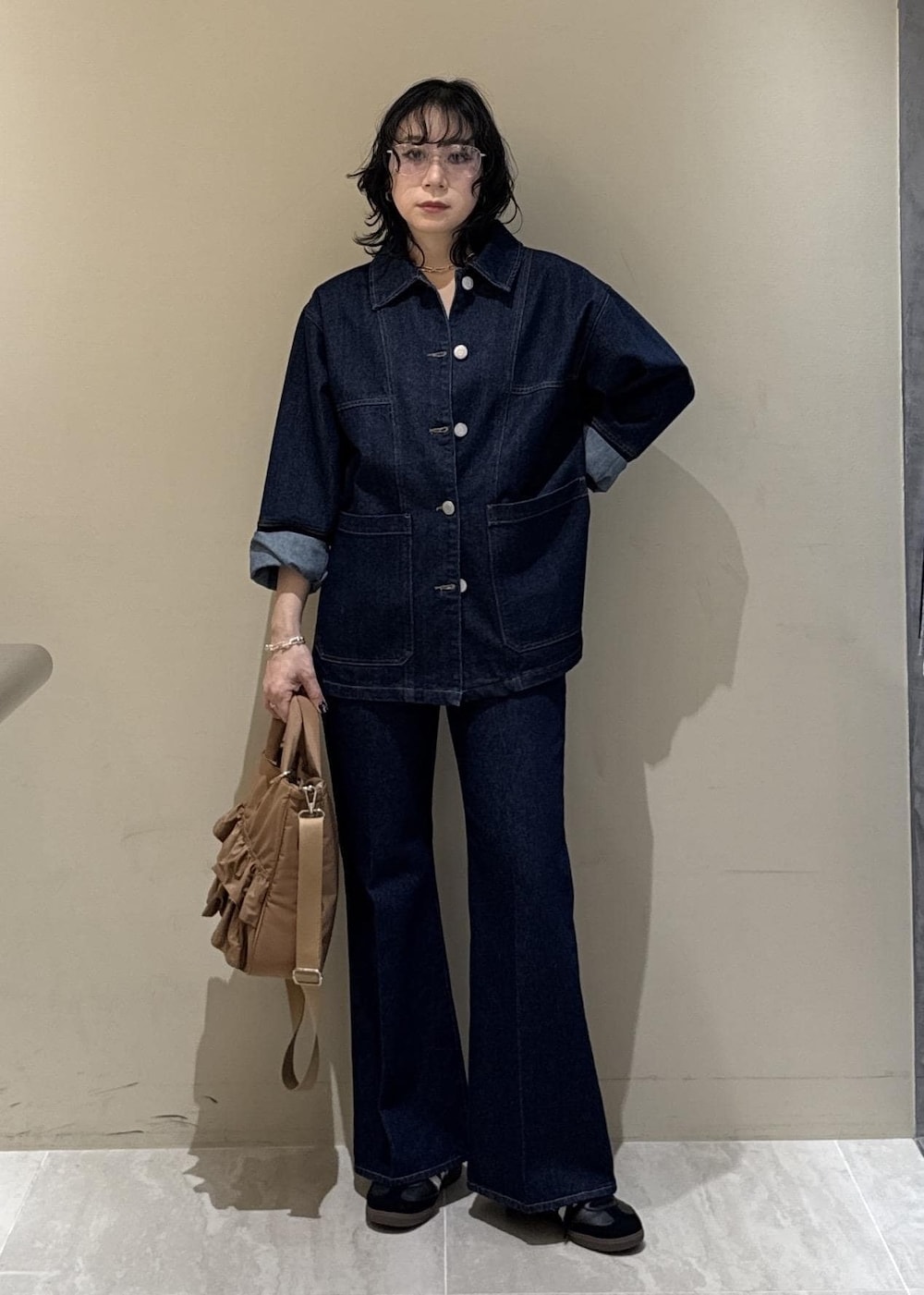 ブルー系のデニムパンツ、ベージュ系のトートバッグを着用したレディースの冬コーディネートの9枚目の写真