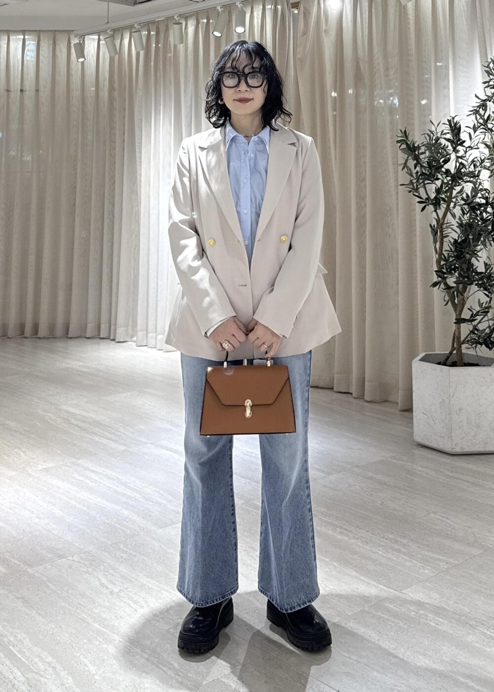 ブラック系のブーツ、イエロー系のハンドバッグ、ブルー系のシャツ/ブラウスを着用したレディースの冬コーディネートの3枚目の写真