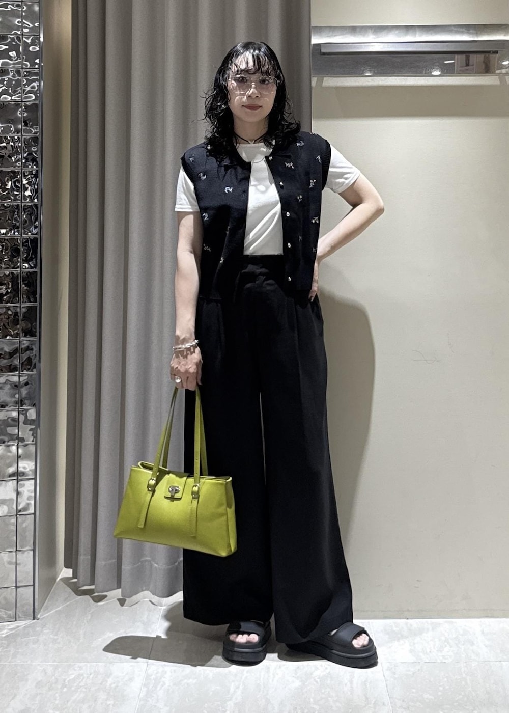 グリーン系のトートバッグ、ブラック系のその他パンツ、ホワイト系のTシャツ/カットソーを着用したレディースの春コーディネートの7枚目の写真