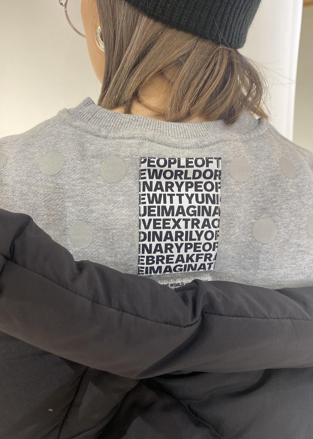 ブラック系のスニーカー、ブラック系のダウンベスト、ピンク系のスカートを着用したレディースの冬コーディネートの4枚目の写真