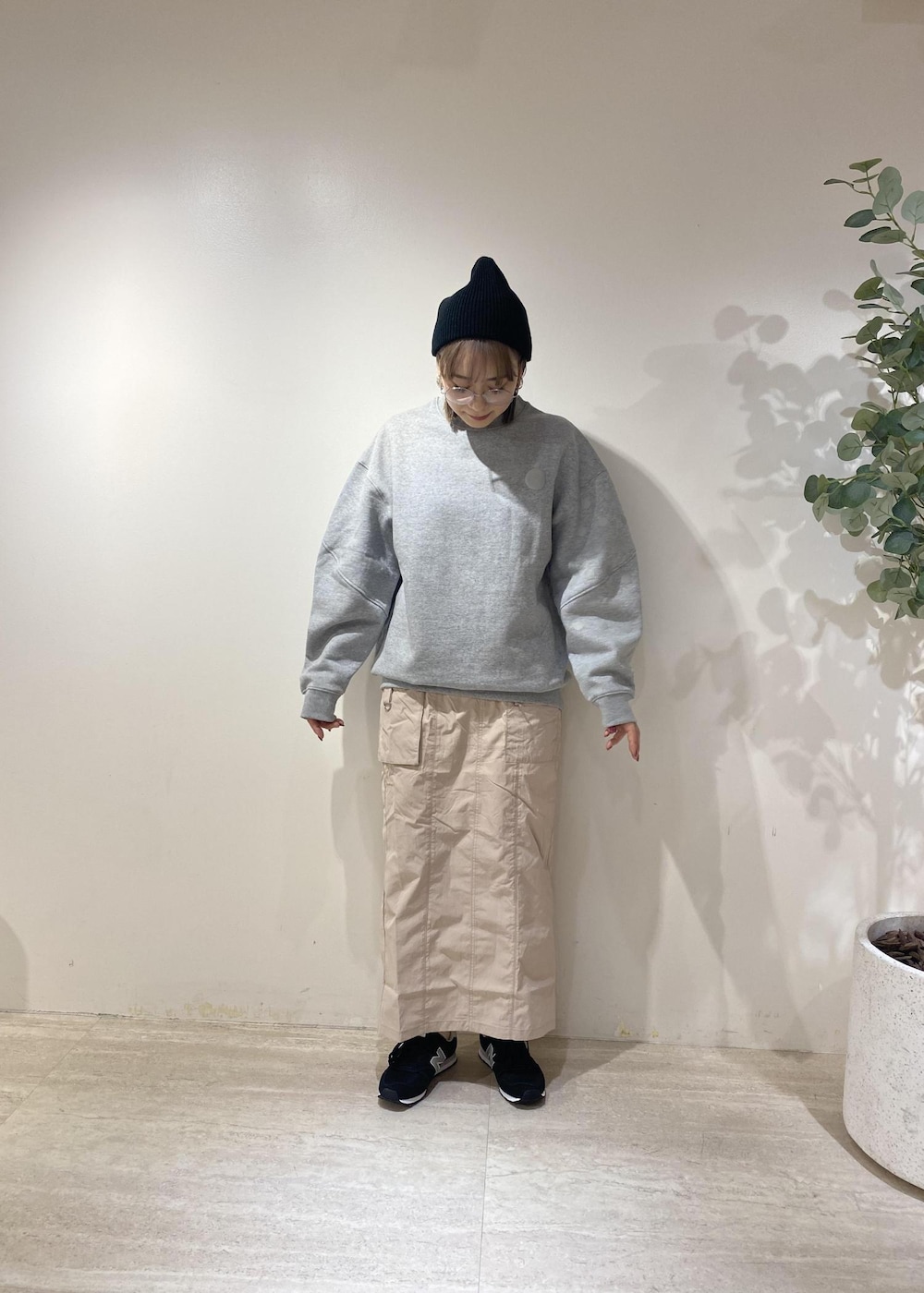 ブラック系のスニーカー、ブラック系のダウンベスト、ピンク系のスカートを着用したレディースの冬コーディネートの2枚目の写真