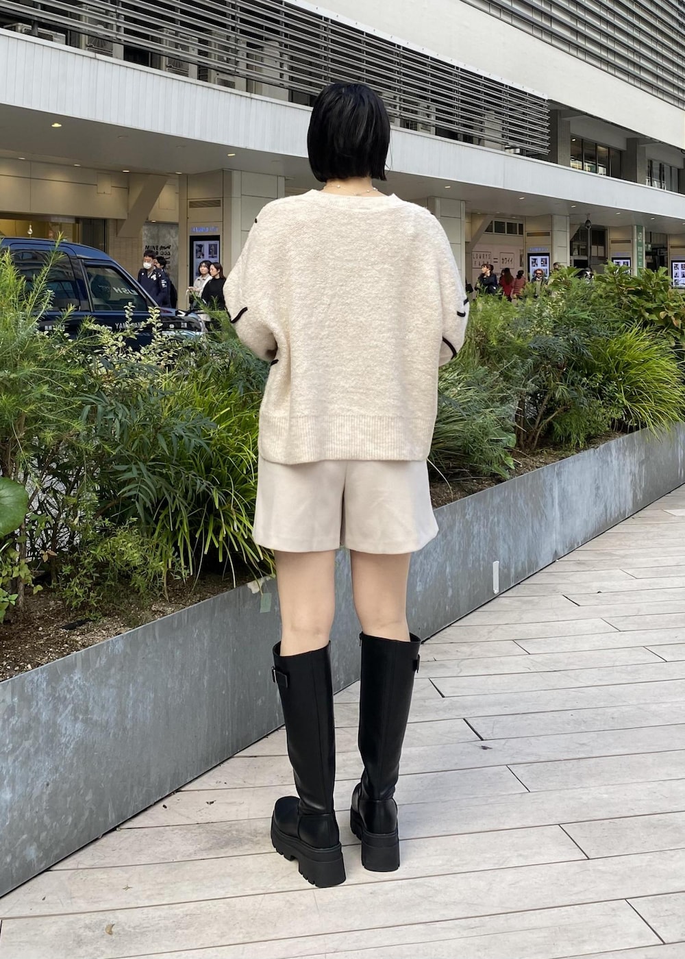 ブラック系のブーツ、ホワイト系のニット/セーター、ベージュ系のその他パンツを着用したレディースの秋コーディネートの2枚目の写真