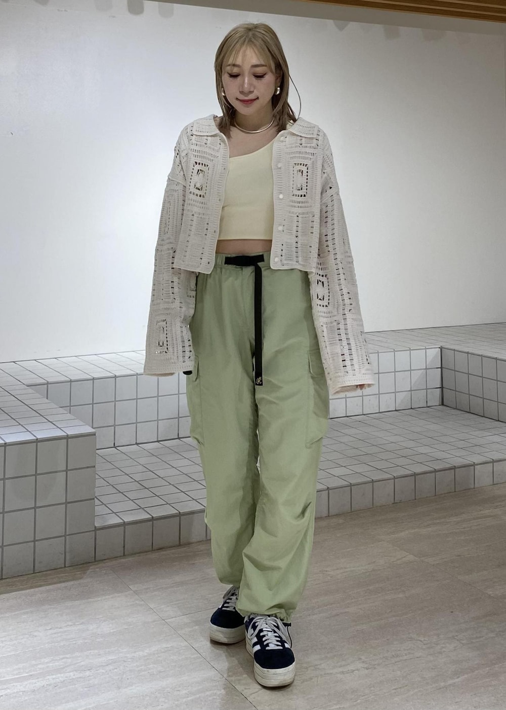 ホワイト系のタンクトップ、ホワイト系のカーディガン/ボレロ、グリーン系のカーゴパンツを着用したレディースの春コーディネートの4枚目の写真
