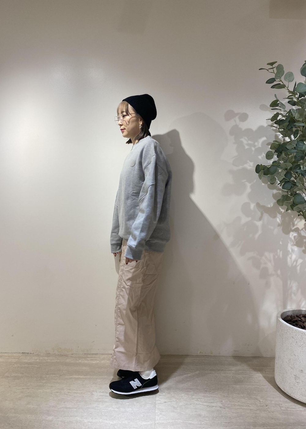 ブラック系のスニーカー、ブラック系のダウンベスト、ピンク系のスカートを着用したレディースの冬コーディネートの3枚目の写真