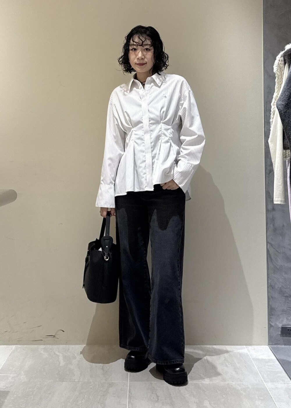 ブラック系のブーツ、ブラック系のショルダーバッグ、グレー系のデニムパンツを着用したレディースの秋コーディネートの8枚目の写真