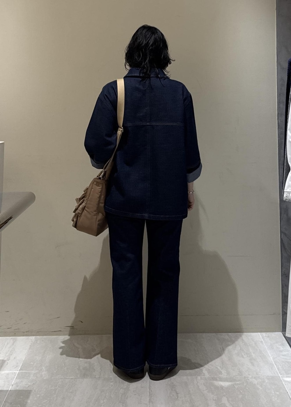 ブルー系のデニムパンツ、ベージュ系のトートバッグを着用したレディースの冬コーディネートの6枚目の写真