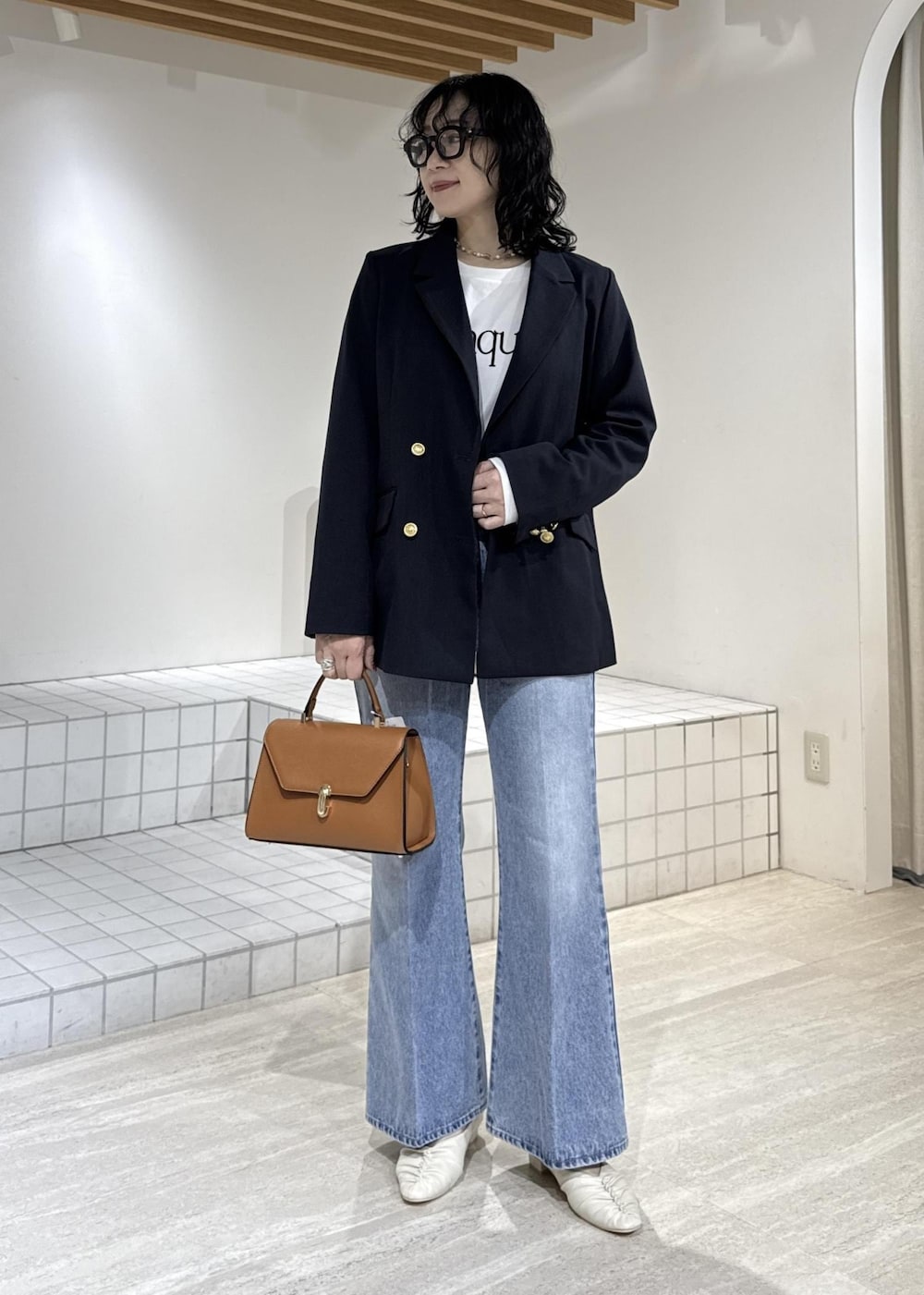 ホワイト系のパンプス、イエロー系のハンドバッグ、ホワイト系のTシャツ/カットソーを着用したレディースの冬コーディネートの2枚目の写真