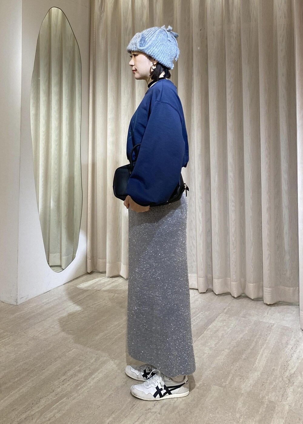 グレー系のスカート、ブルー系のスウェットを着用したレディースの冬コーディネートの4枚目の写真