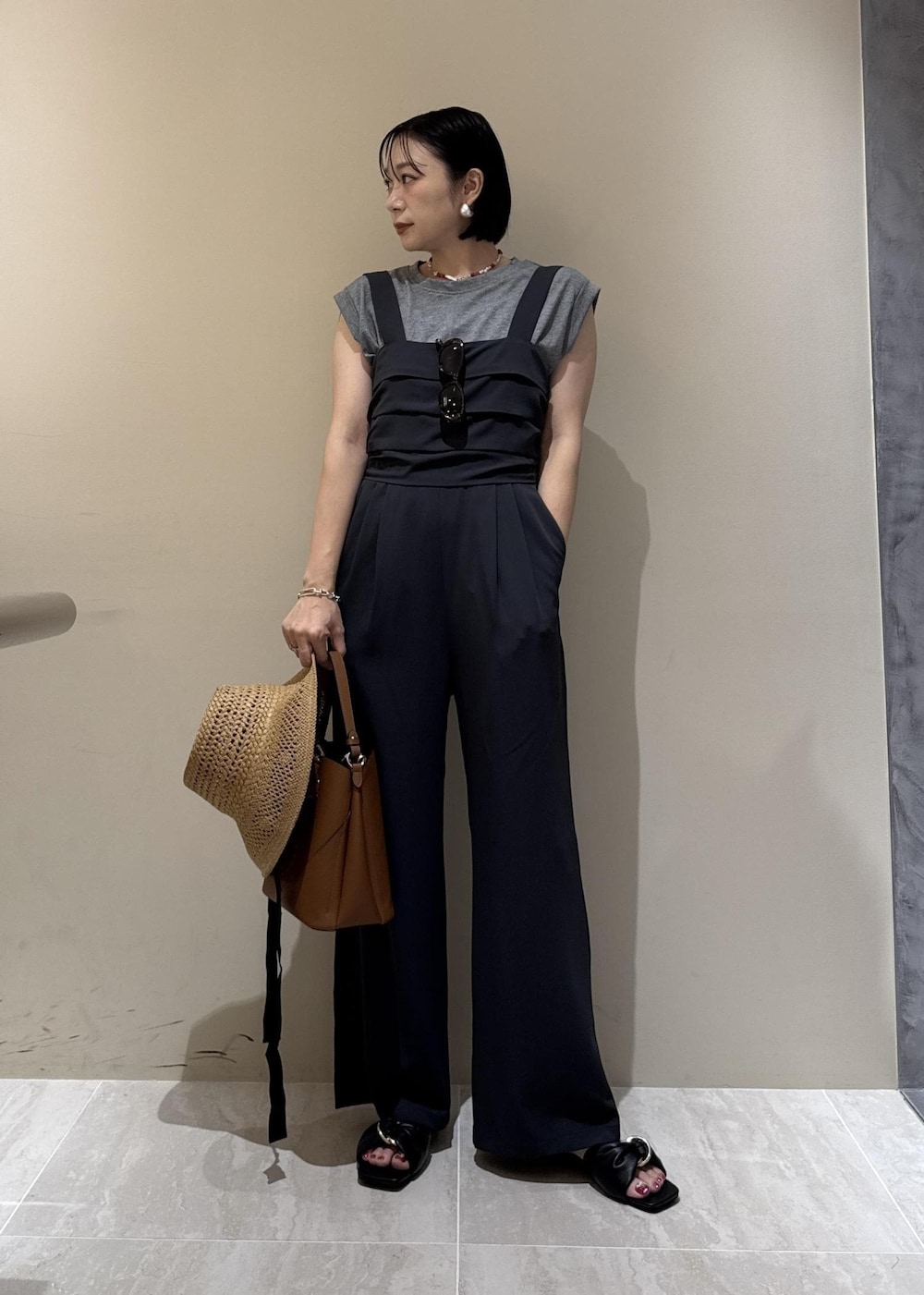 ブラウン系のショルダーバッグ、ブラック系のサンダル、グレー系のTシャツ/カットソーを着用したレディースの夏コーディネートの7枚目の写真