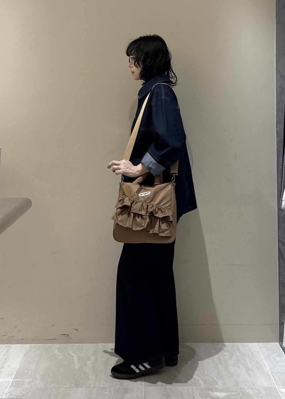 ブルー系のデニムパンツ、ベージュ系のトートバッグを着用したレディースの冬コーディネートの7枚目の写真