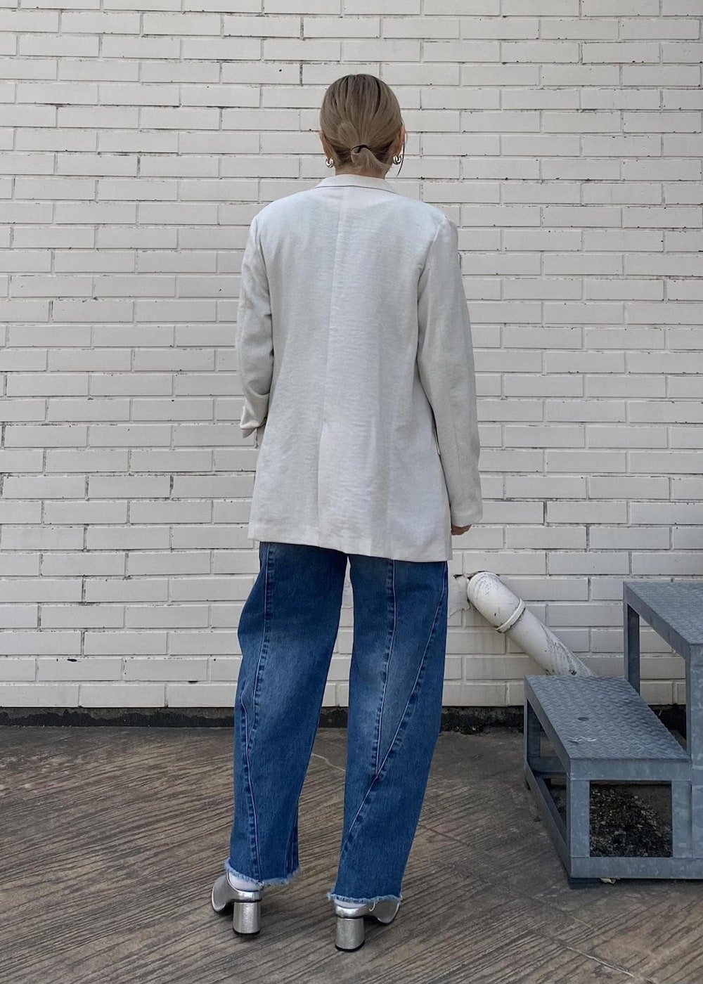 シルバー系のその他シューズ、ブルー系のデニムパンツ、グリーン系のニット/セーターを着用したレディースの春コーディネートの2枚目の写真