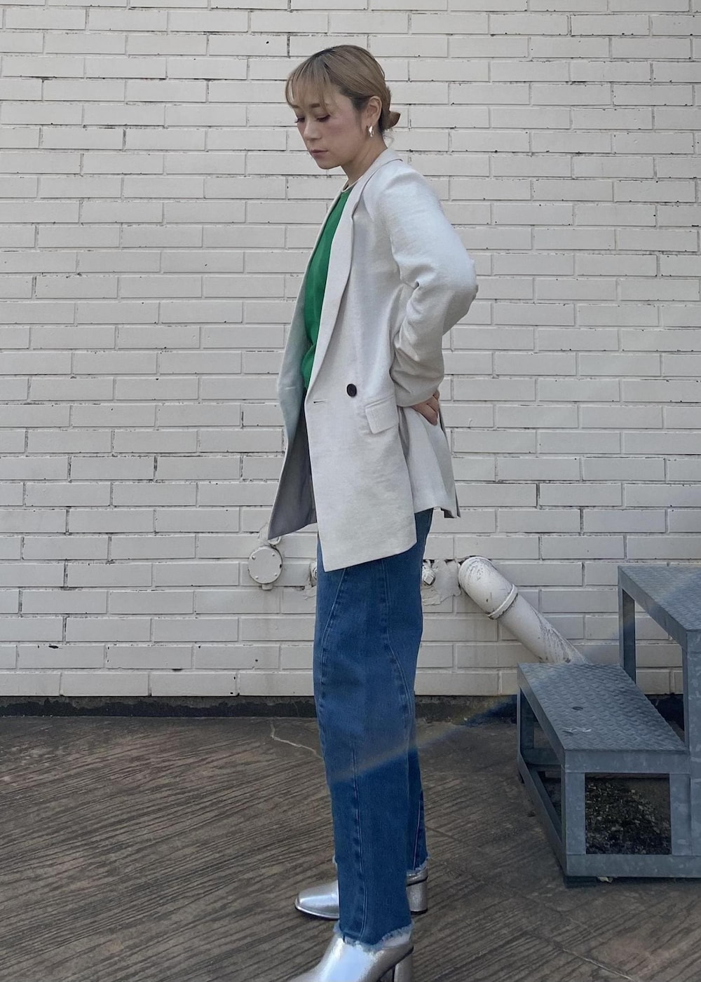 シルバー系のその他シューズ、ブルー系のデニムパンツ、グリーン系のニット/セーターを着用したレディースの春コーディネートの3枚目の写真
