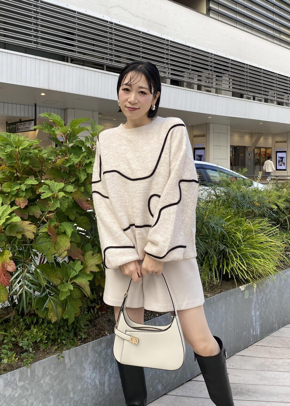 ブラック系のブーツ、ホワイト系のニット/セーター、ベージュ系のその他パンツを着用したレディースの秋コーディネートの6枚目の写真