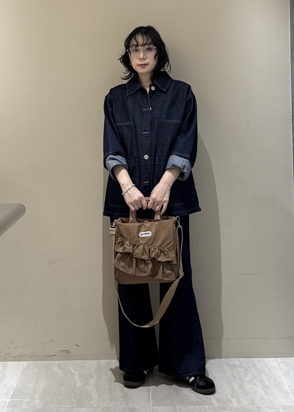 ブルー系のデニムパンツ、ベージュ系のトートバッグを着用したレディースの冬コーディネートの4枚目の写真
