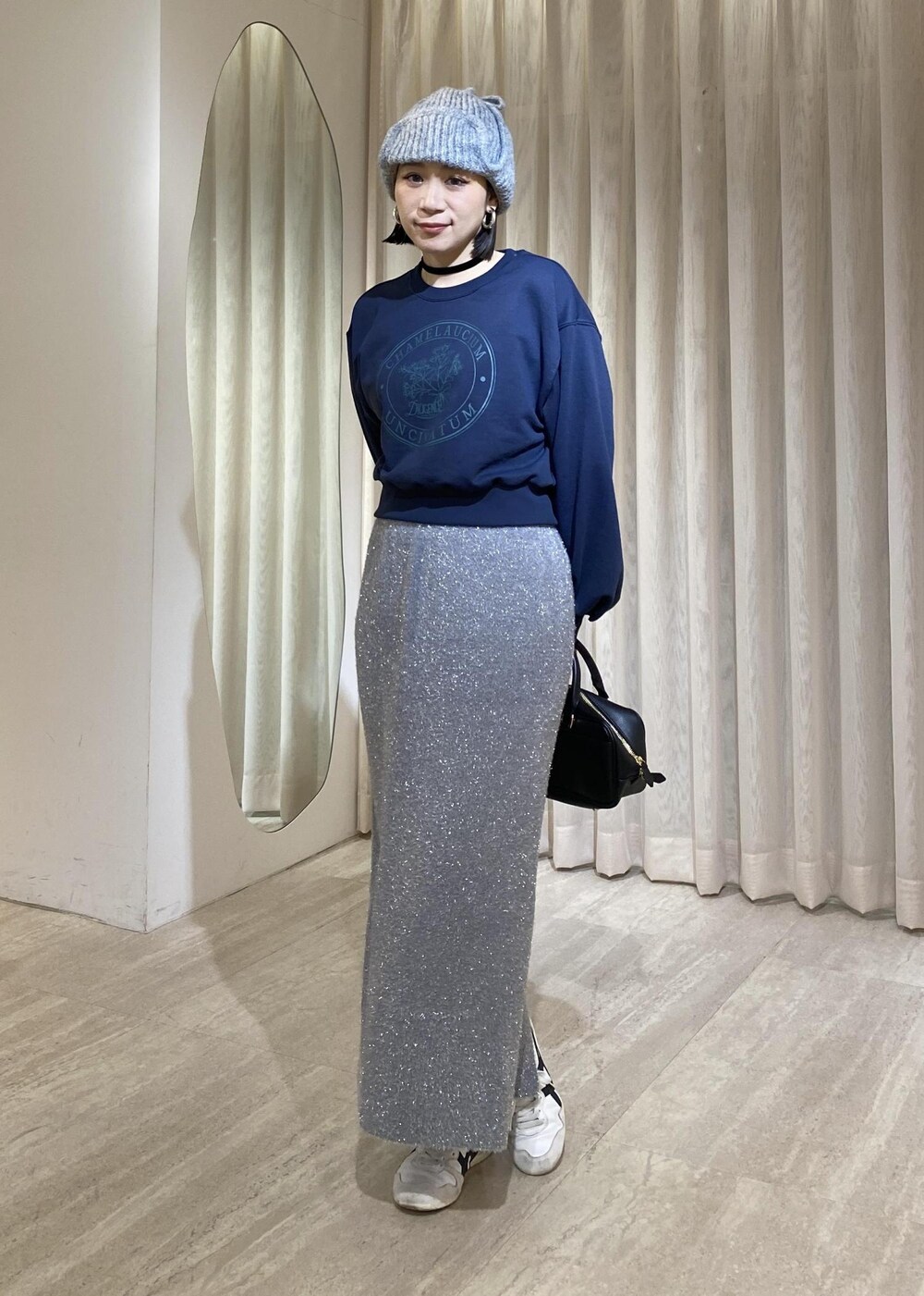 グレー系のスカート、ブルー系のスウェットを着用したレディースの冬コーディネートの2枚目の写真