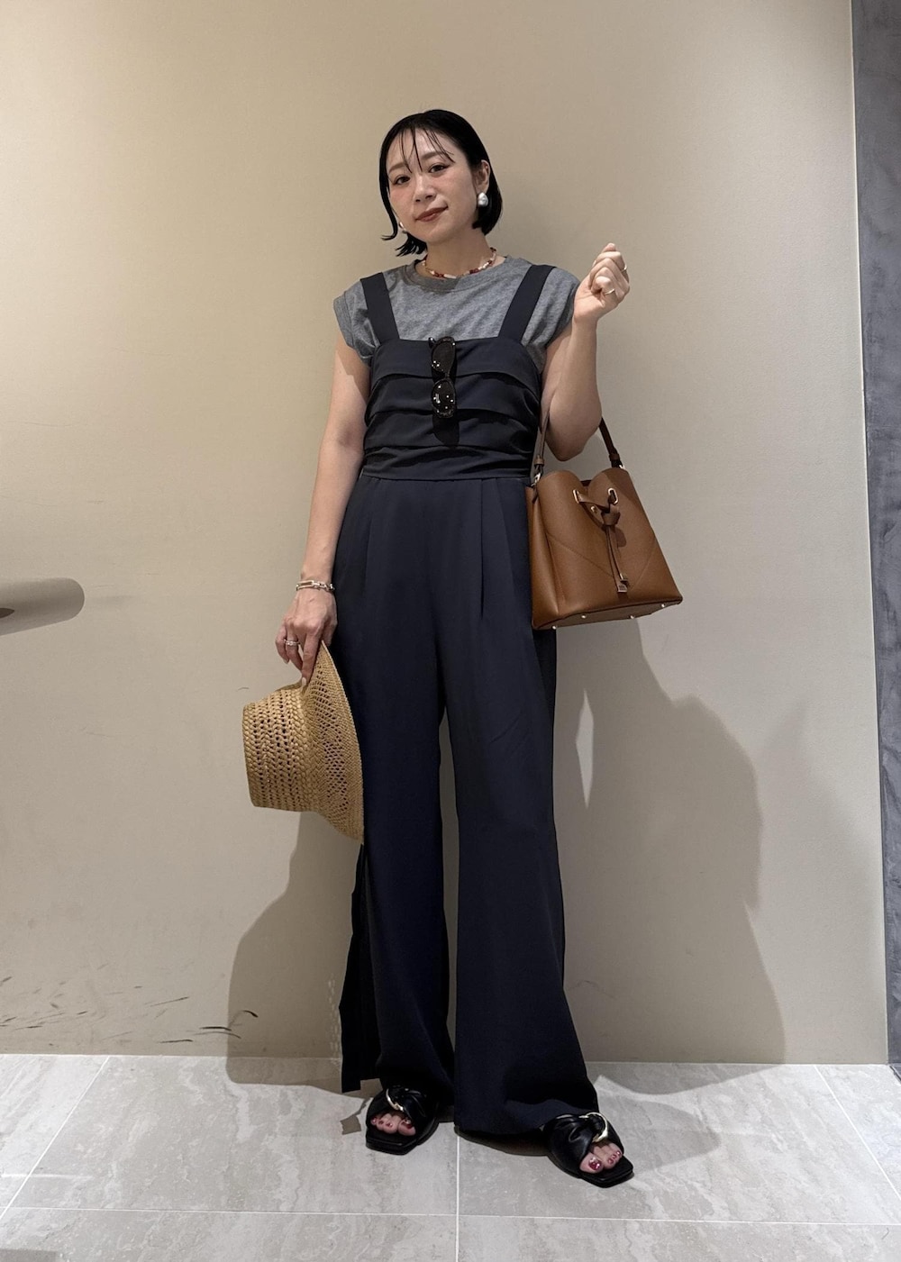 ブラウン系のショルダーバッグ、ブラック系のサンダル、グレー系のTシャツ/カットソーを着用したレディースの夏コーディネートの8枚目の写真