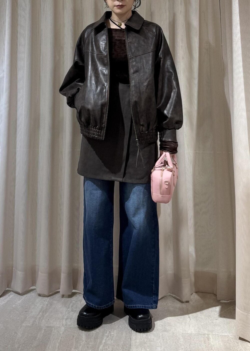 ブラック系のキャミソール、ブラック系のブーツ、ブラウン系のスカートを着用したレディースの秋コーディネートの2枚目の写真