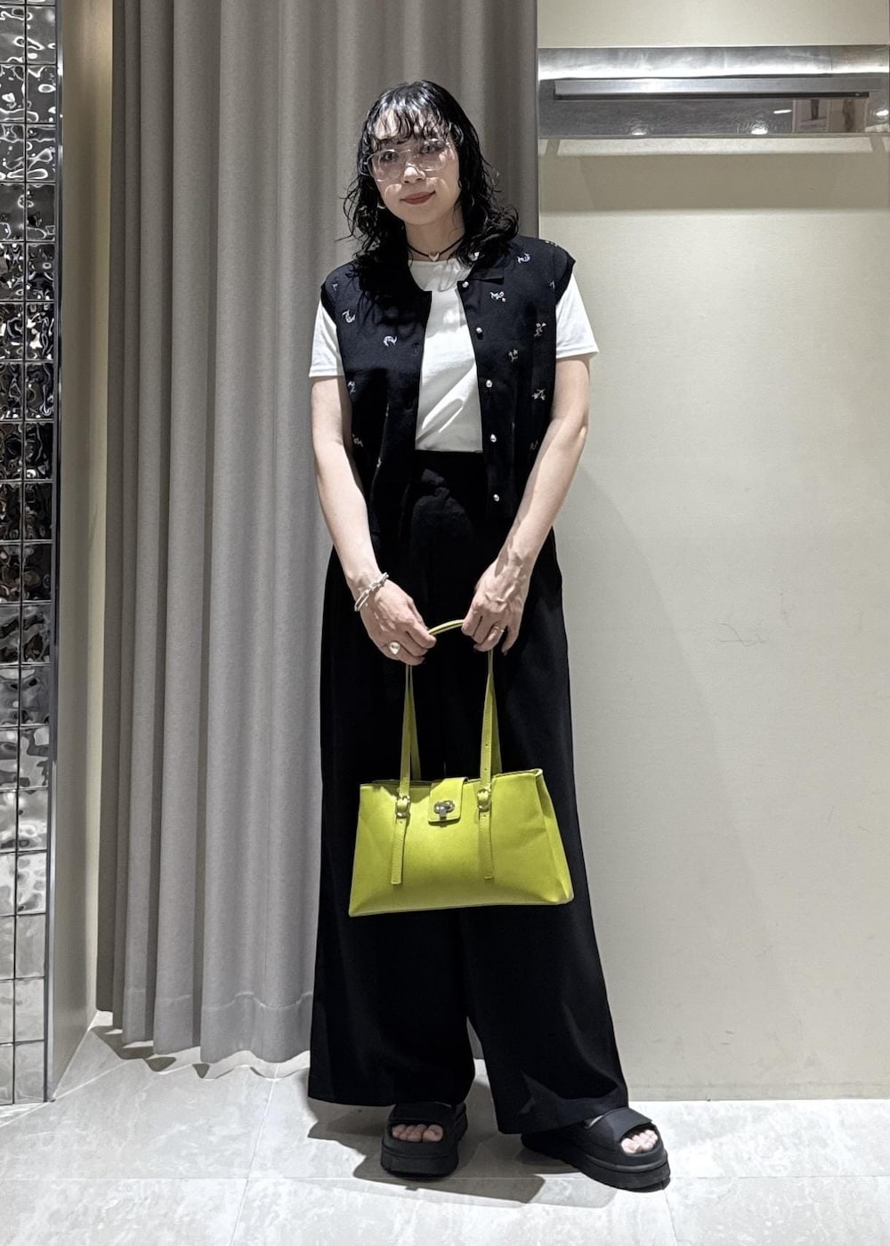 グリーン系のトートバッグ、ブラック系のその他パンツ、ホワイト系のTシャツ/カットソーを着用したレディースの春コーディネートの4枚目の写真