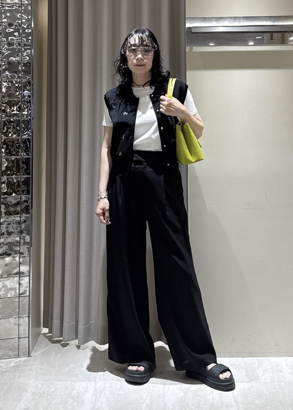 グリーン系のトートバッグ、ブラック系のその他パンツ、ホワイト系のTシャツ/カットソーを着用したレディースの春コーディネートの3枚目の写真