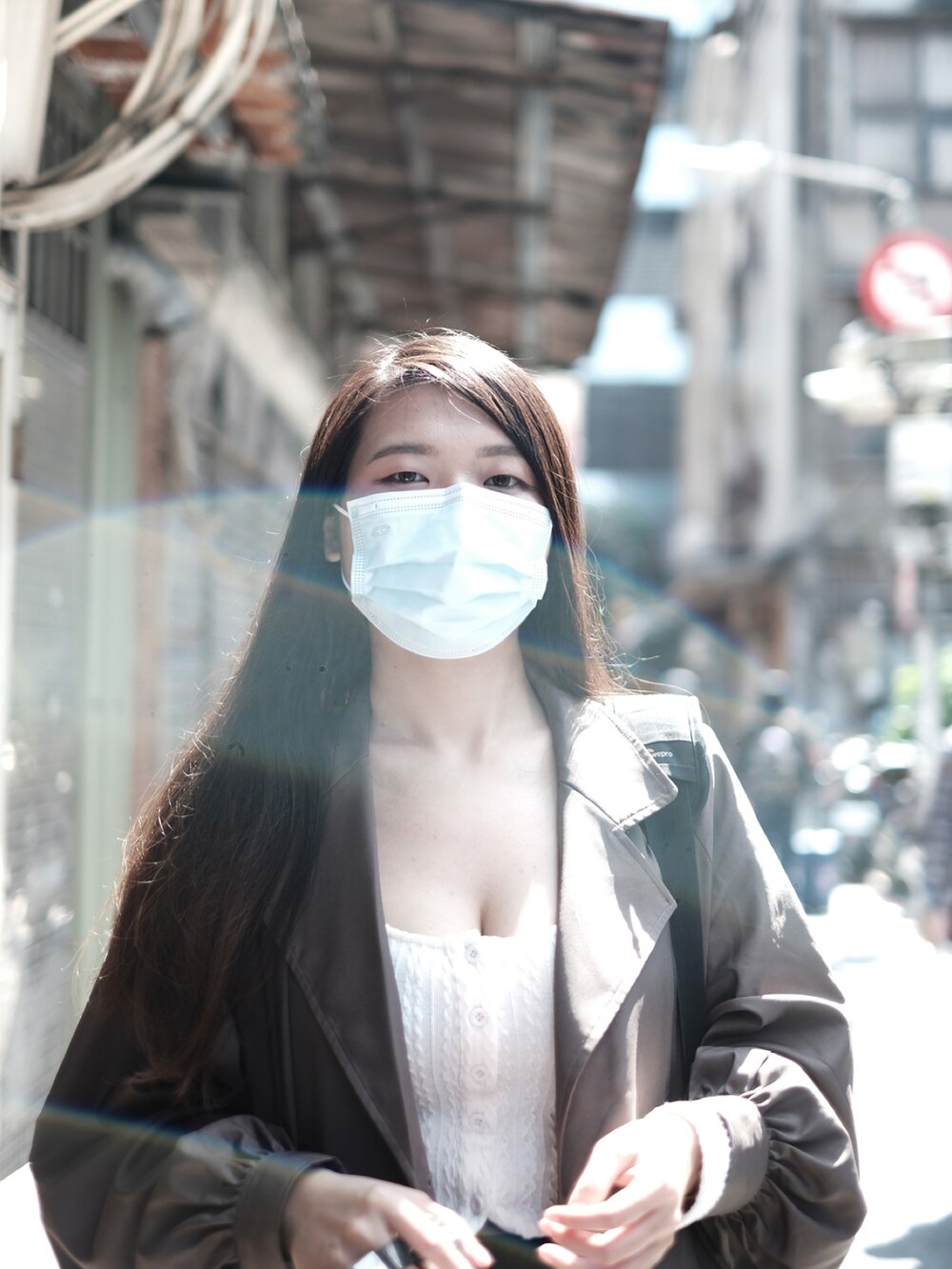 ブラウン系のトレンチコート、ホワイト系のトップス、ブラック系のその他パンツを着用したレディースの秋コーディネートの2枚目の写真