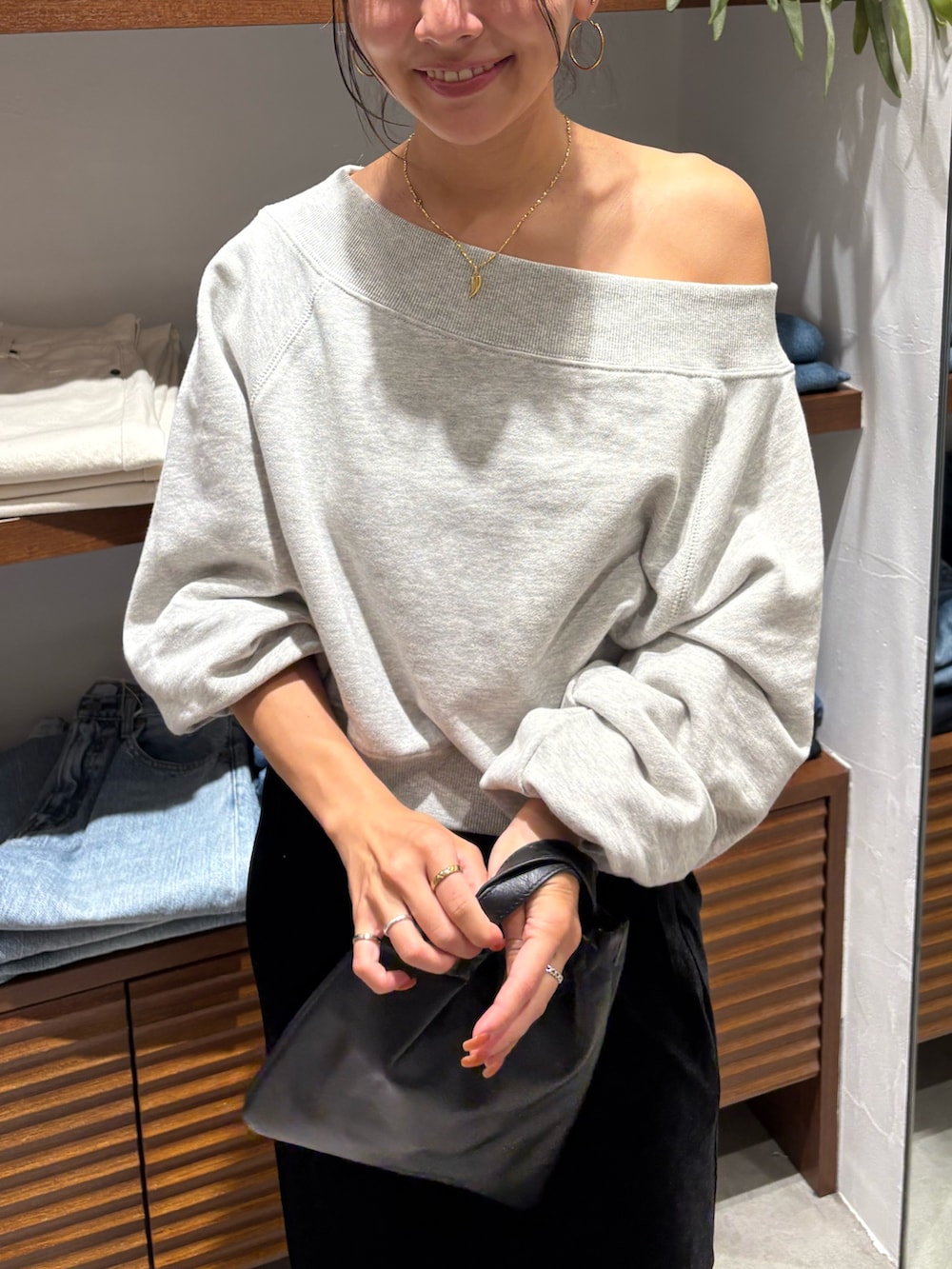 グレー系のスウェット、ブラック系のスカートを着用したレディースの秋コーディネートの4枚目の写真