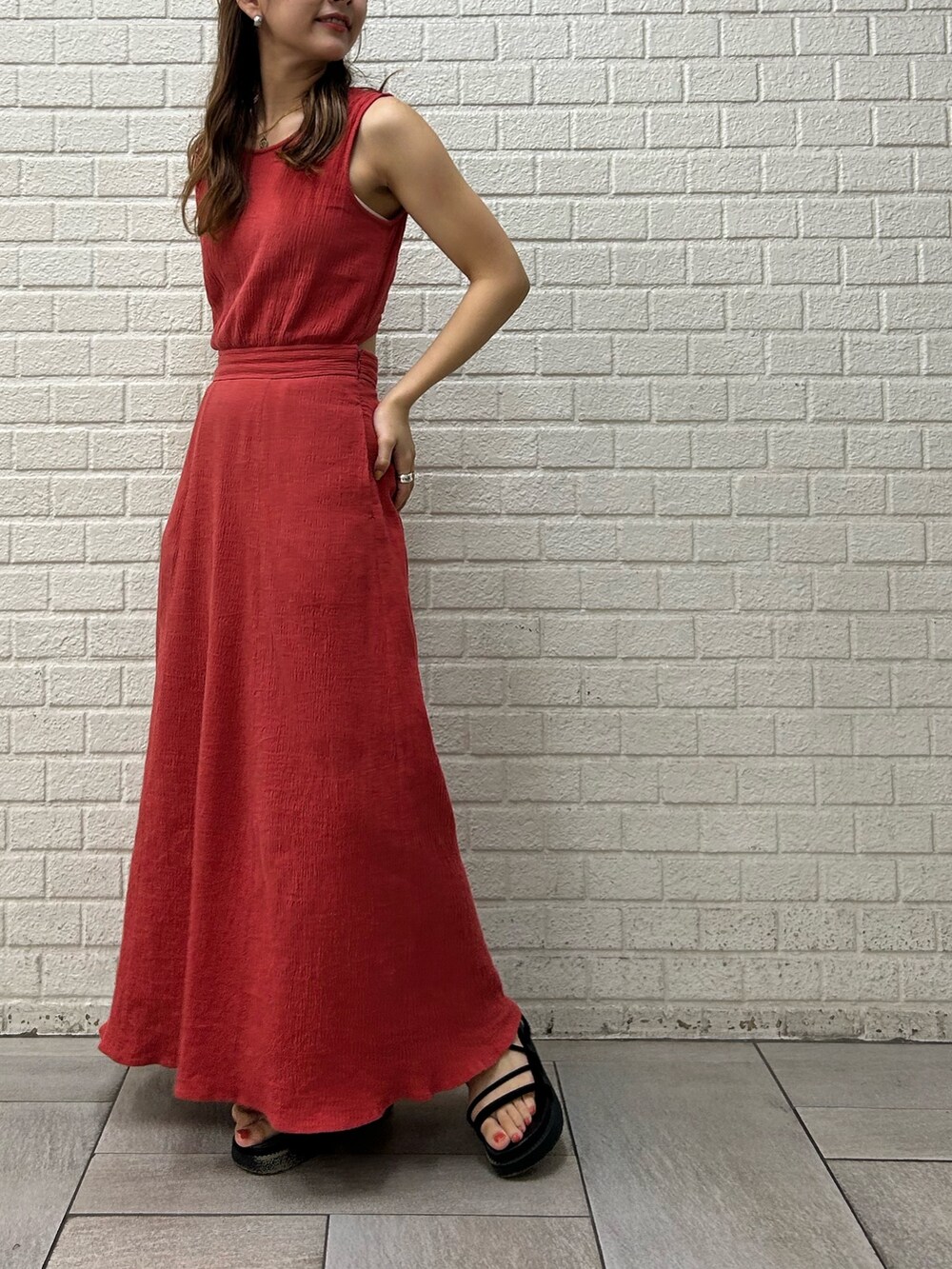 オレンジ系のワンピース、ホワイト系のキャミソールを着用したレディースの夏コーディネートの3枚目の写真