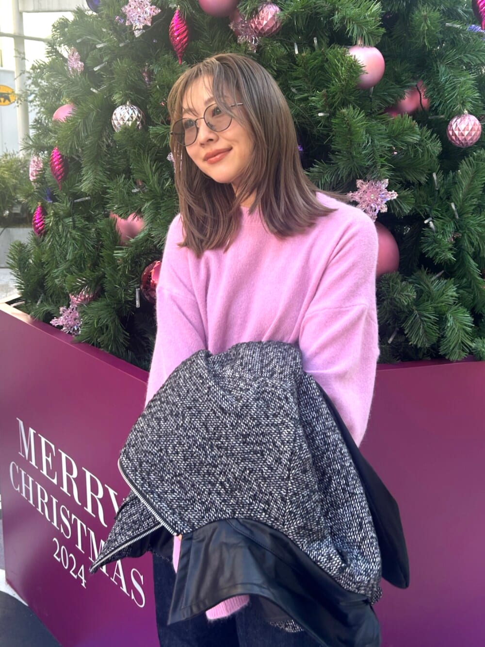 ブラック系のブルゾン、ブルー系のデニムパンツ、ピンク系のニット/セーターを着用したレディースの冬コーディネートの4枚目の写真