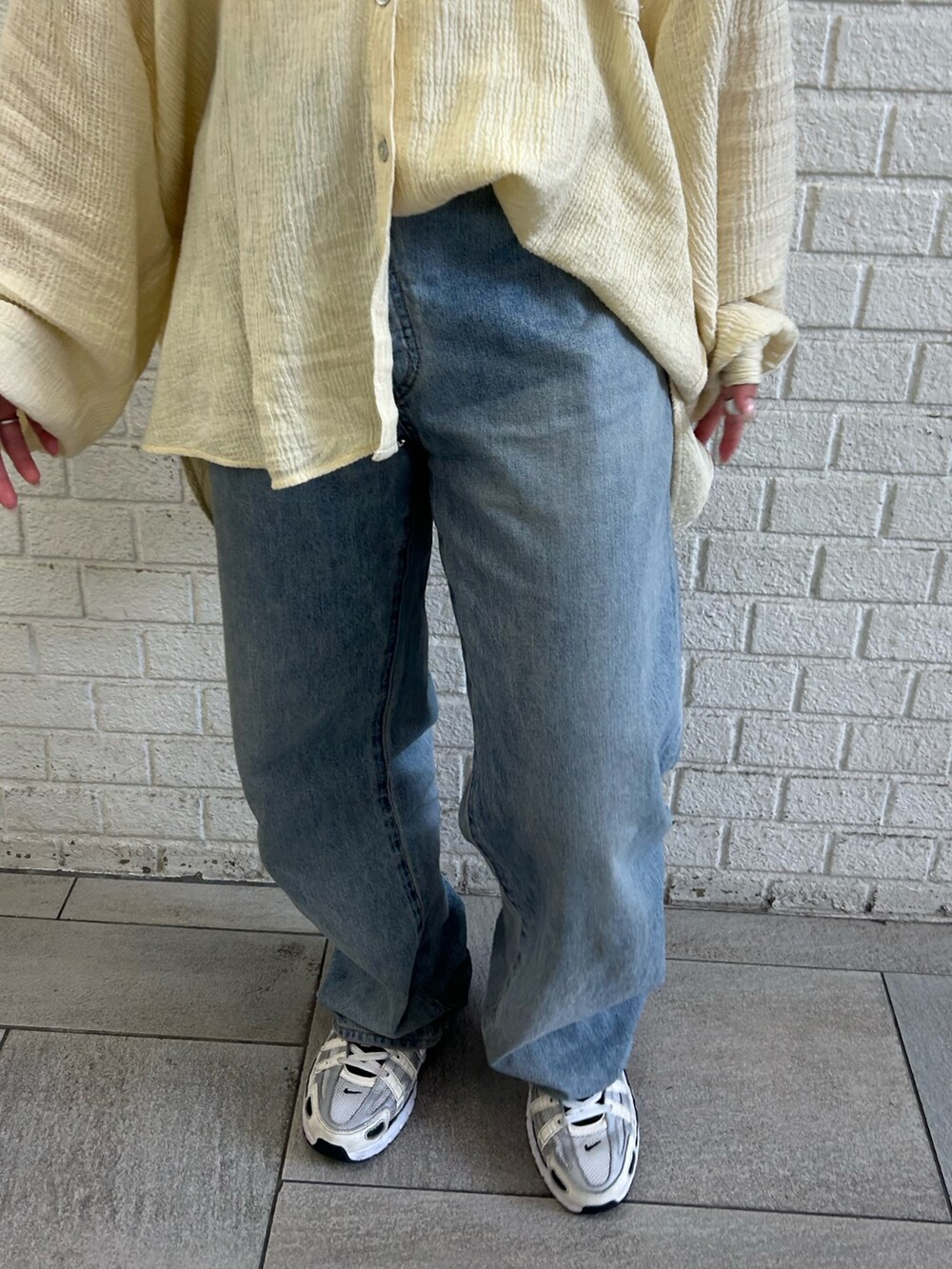 イエロー系のシャツ/ブラウス、ブルー系のデニムパンツを着用したレディースの春コーディネートの5枚目の写真