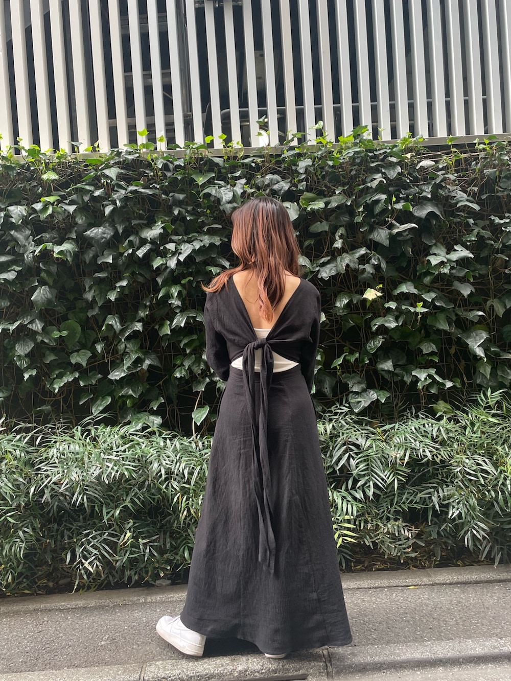 ホワイト系のハンドバッグ、ブラック系のワンピースを着用したレディースの春コーディネートの3枚目の写真