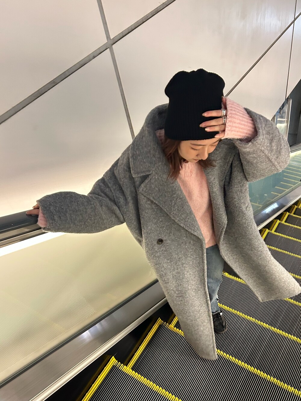 ピンク系のニット/セーター、グレー系のチェスターコートを着用したレディースの冬コーディネートの2枚目の写真