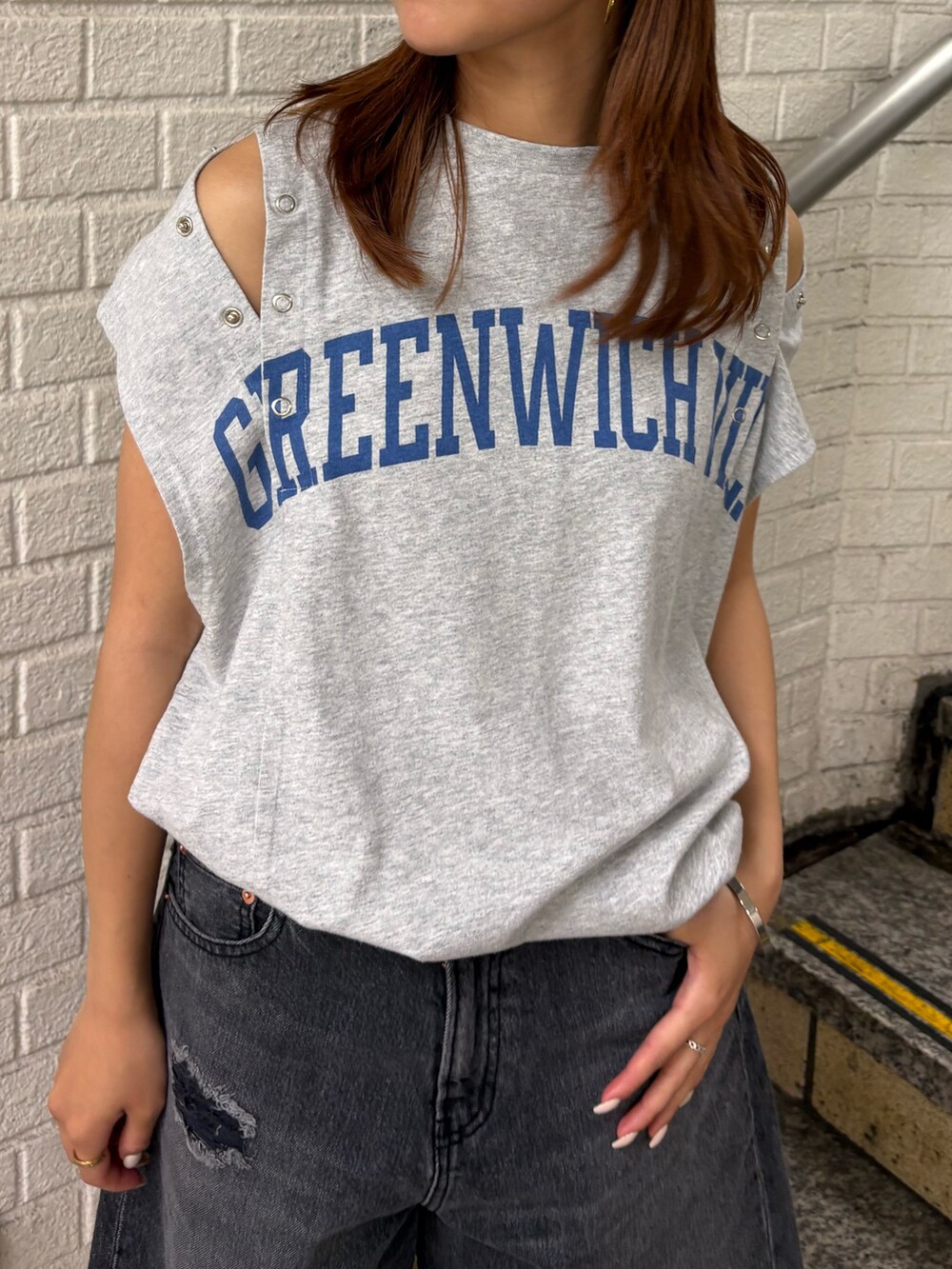 グレー系のタンクトップ、ブラック系のデニムパンツ、ホワイト系のキャップを着用したレディースの夏コーディネートの4枚目の写真